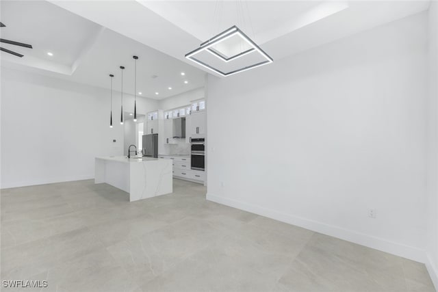 unfurnished living room with recessed lighting, a sink, a ceiling fan, and baseboards