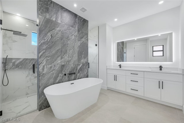 full bathroom featuring marble finish floor, a sink, a soaking tub, and a marble finish shower