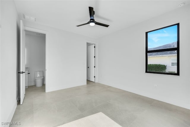 unfurnished bedroom featuring baseboards, visible vents, a ceiling fan, and ensuite bathroom