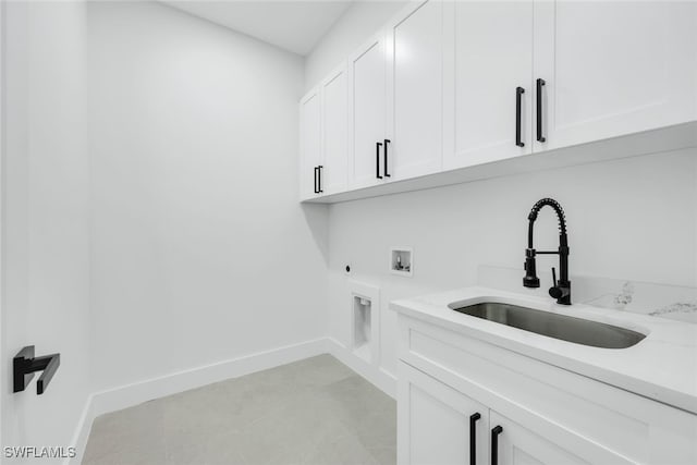 laundry area with washer hookup, cabinet space, a sink, electric dryer hookup, and baseboards