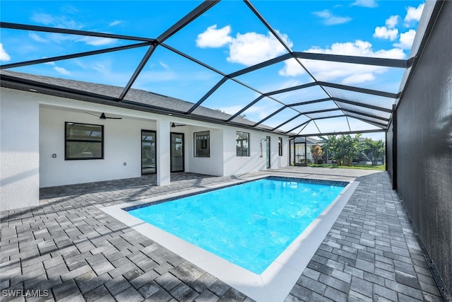 view of swimming pool featuring ceiling fan, a lanai, and a patio area