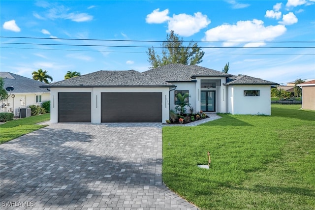 view of front of home featuring decorative driveway, central air condition unit, stucco siding, a front yard, and a garage