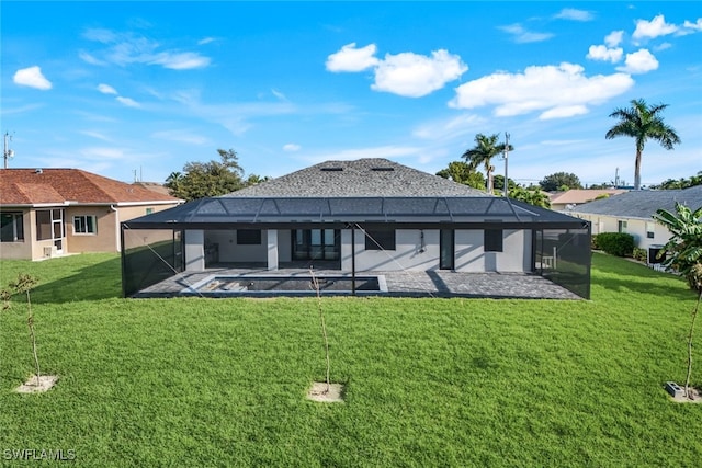 back of property with a lanai, a patio area, and a lawn