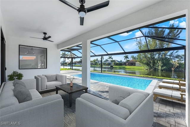 view of pool with a patio, a lanai, ceiling fan, an outdoor living space, and a water view