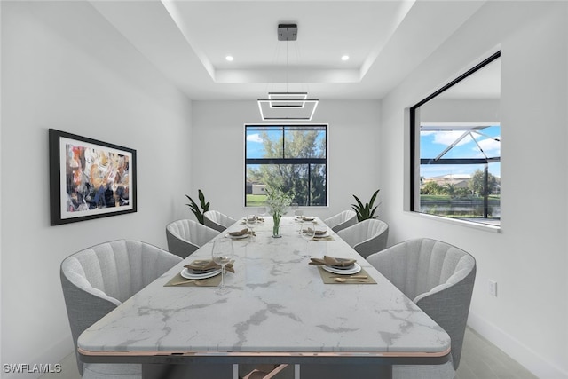 dining area featuring recessed lighting, a raised ceiling, and baseboards