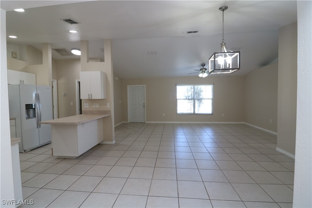 kitchen featuring white refrigerator with ice dispenser, white cabinets, ceiling fan with notable chandelier, light tile patterned floors, and decorative light fixtures