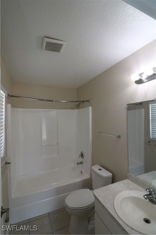 full bathroom featuring vanity, a textured ceiling, shower / tub combination, toilet, and tile patterned floors