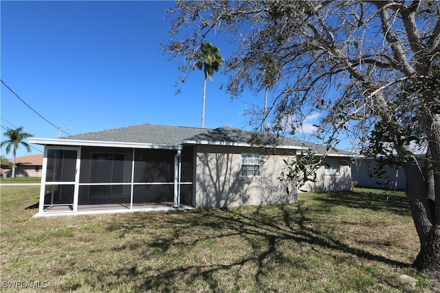 back of property with a lawn and a sunroom