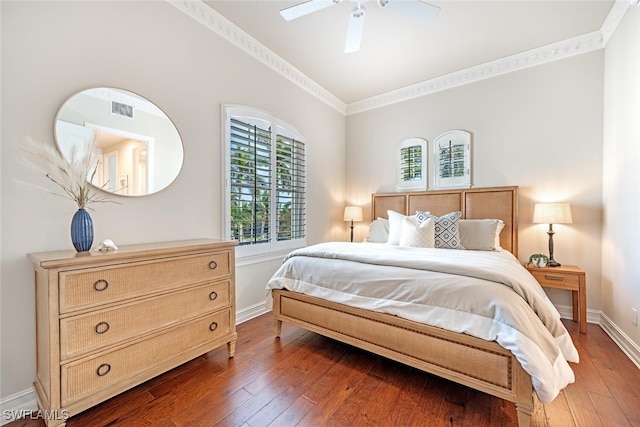 bedroom with wood-type flooring, crown molding, visible vents, and baseboards