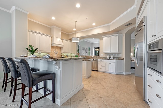 kitchen with a kitchen bar, white cabinetry, kitchen peninsula, and pendant lighting