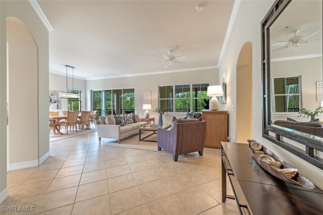 living room featuring crown molding, light tile patterned floors, and ceiling fan