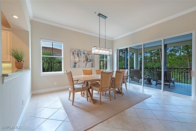 dining area featuring light tile patterned floors, a notable chandelier, baseboards, and crown molding