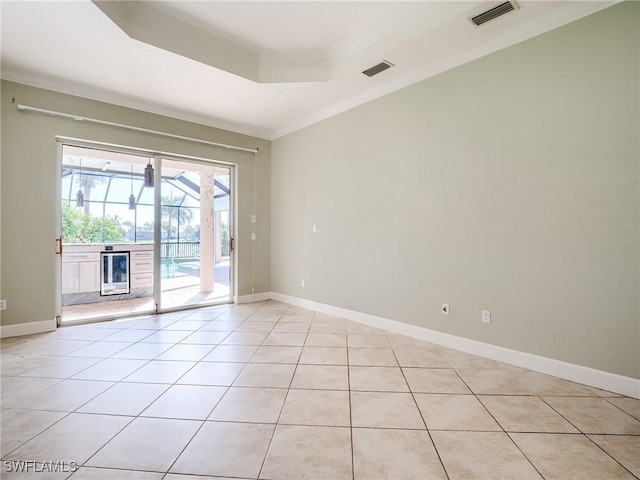 spare room with light tile patterned floors, a tray ceiling, ornamental molding, and beverage cooler