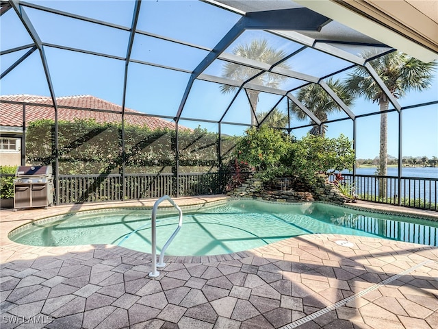 view of pool with a patio, a water view, area for grilling, and glass enclosure