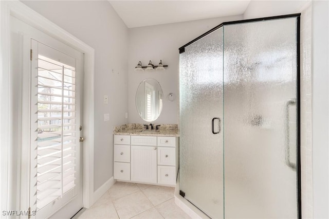 bathroom with tile patterned flooring, vanity, and walk in shower