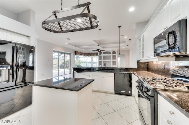 kitchen featuring ceiling fan, a center island, black appliances, white cabinets, and decorative light fixtures