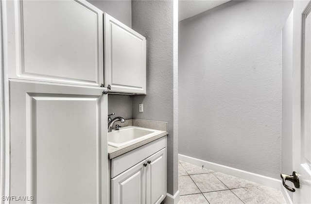 clothes washing area with sink and light tile patterned floors