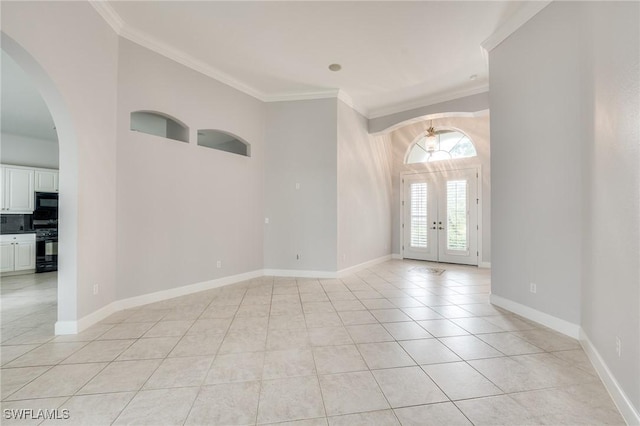 foyer with light tile patterned floors, crown molding, and french doors