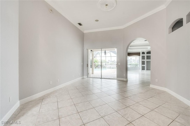 spare room featuring ornamental molding and light tile patterned flooring