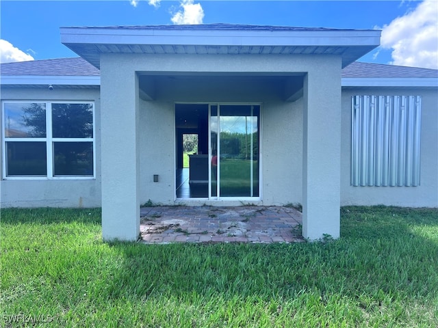 rear view of property featuring a lawn and a patio