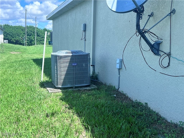 view of home's exterior with a lawn and central AC