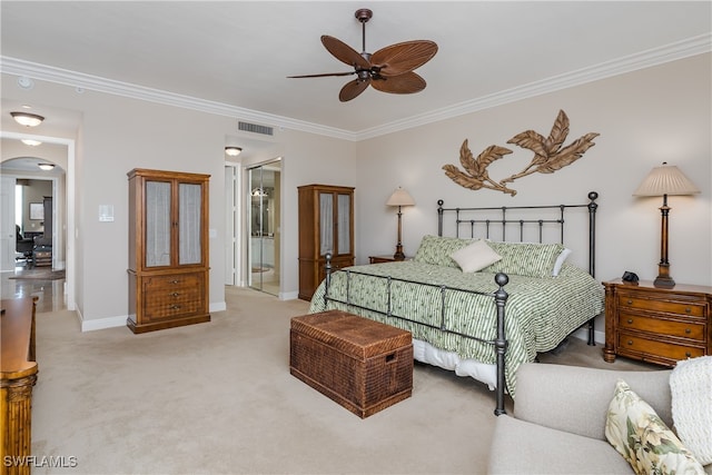 carpeted bedroom featuring ceiling fan, ensuite bath, and ornamental molding