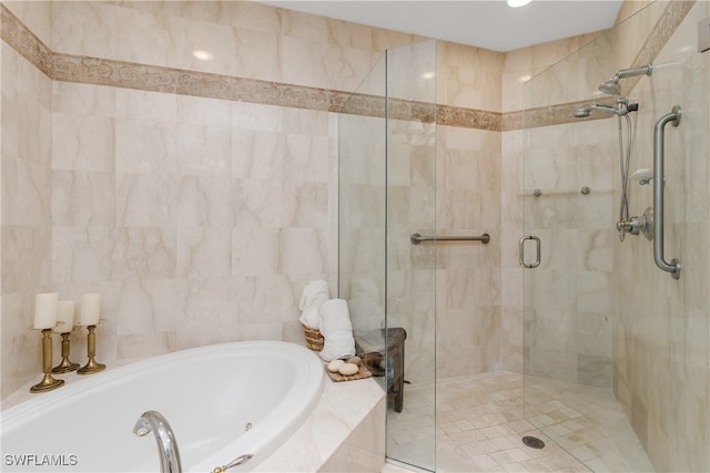 bathroom with shower with separate bathtub and tile walls