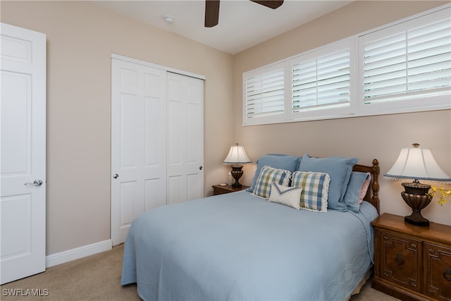 carpeted bedroom with ceiling fan and a closet