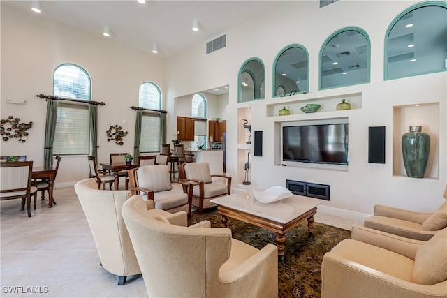 tiled living room featuring a towering ceiling