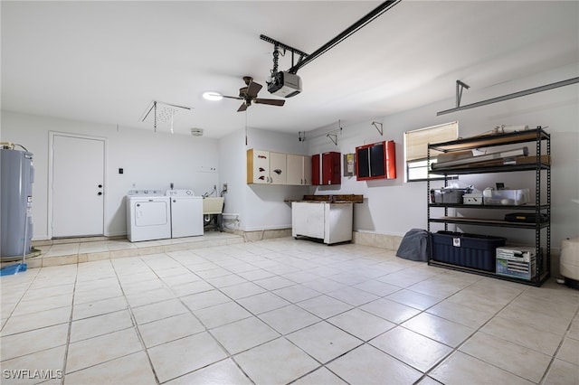 garage with a garage door opener, water heater, ceiling fan, and independent washer and dryer