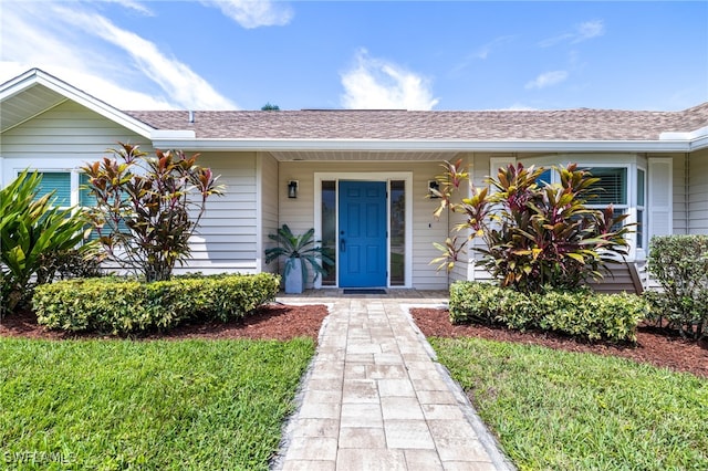 2110 Sebastian Ct, Alva, FL 33920 - view of exterior entry with a shingled roof and a lawn
