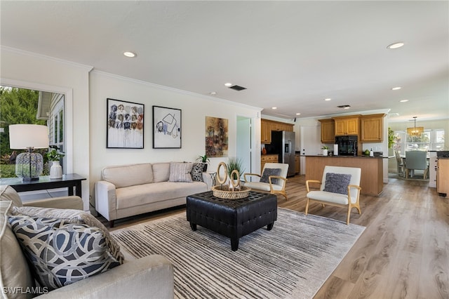 living room with ornamental molding and light hardwood / wood-style floors