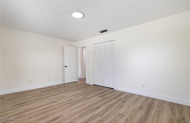 unfurnished bedroom featuring light hardwood / wood-style flooring and a closet