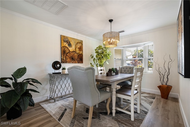 dining space featuring an inviting chandelier, hardwood / wood-style flooring, and ornamental molding