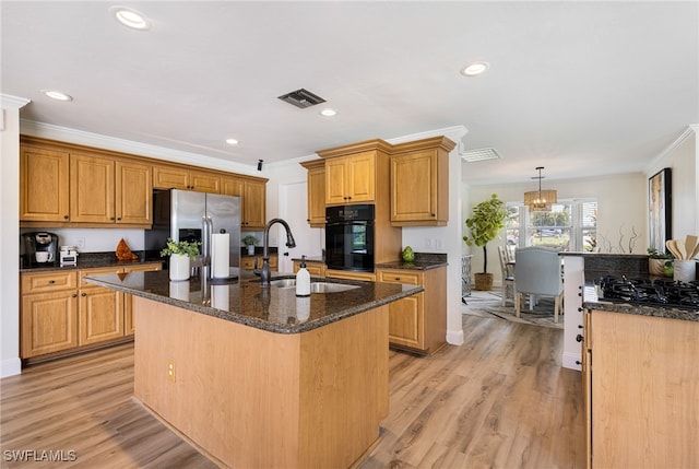 kitchen featuring black appliances, a center island with sink, light hardwood / wood-style floors, and sink