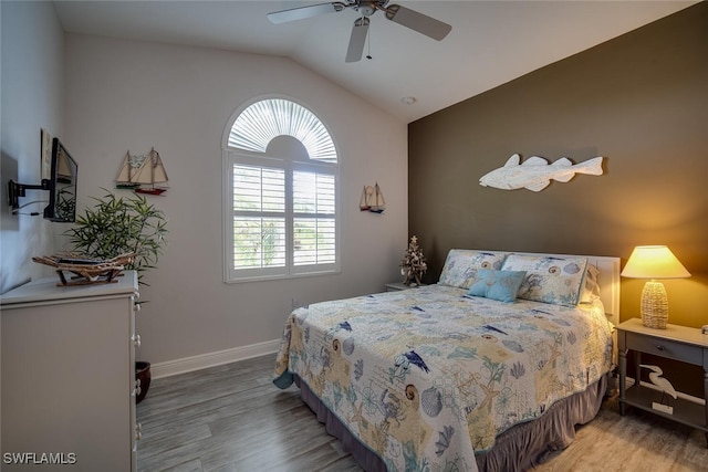 bedroom with ceiling fan, lofted ceiling, and hardwood / wood-style floors