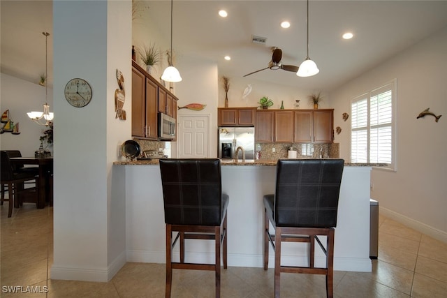 kitchen with stainless steel appliances, lofted ceiling, and decorative light fixtures