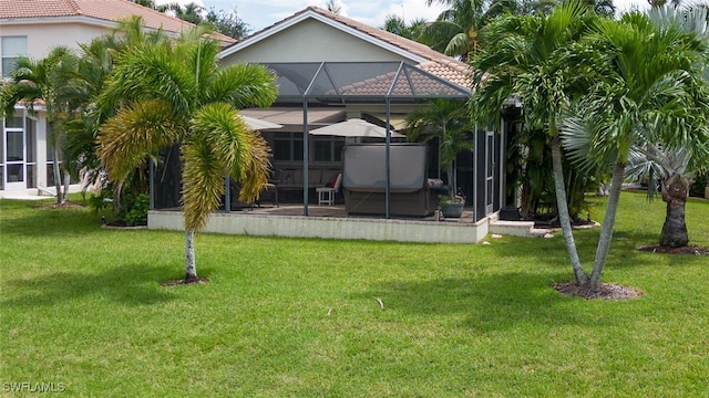 back of house featuring a lawn and a lanai