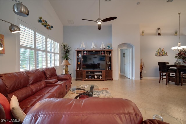 living room with ceiling fan with notable chandelier and high vaulted ceiling