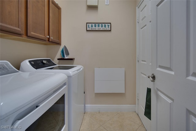 washroom with cabinets, light tile patterned flooring, and washer and dryer