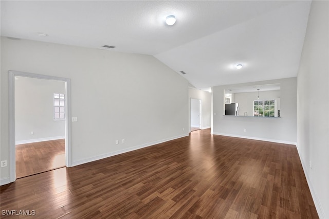 unfurnished living room featuring vaulted ceiling and hardwood / wood-style floors