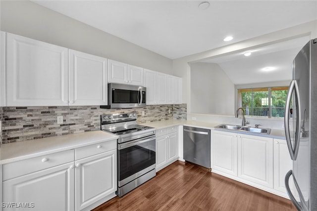 kitchen featuring white cabinets, stainless steel appliances, lofted ceiling, dark hardwood / wood-style floors, and sink