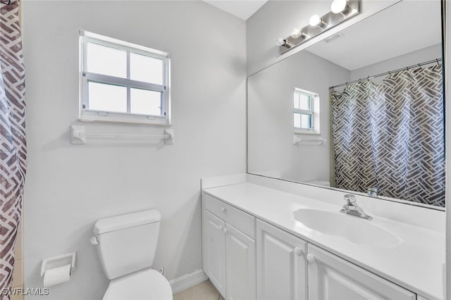 bathroom featuring vanity, plenty of natural light, and toilet