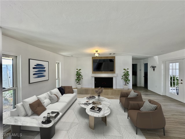 living room featuring a textured ceiling, french doors, and hardwood / wood-style flooring