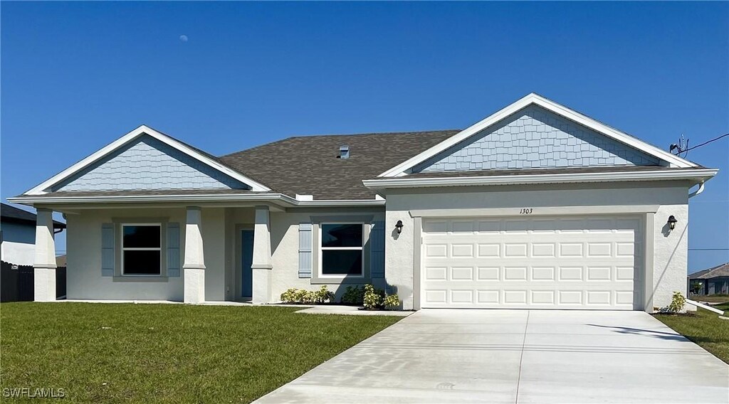 1303 NW 40th Pl, Cape Coral, FL 33993 - view of front of house with stucco siding, concrete driveway, a front lawn, an attached garage, and a shingled roof