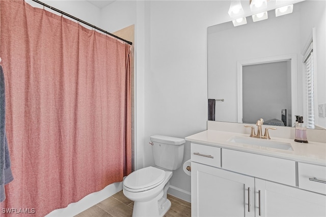 bathroom featuring a shower with shower curtain, hardwood / wood-style floors, vanity, and toilet