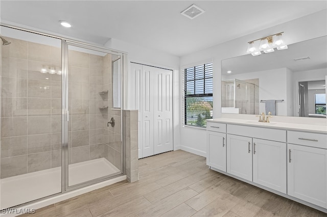 bathroom with vanity, an enclosed shower, and hardwood / wood-style flooring