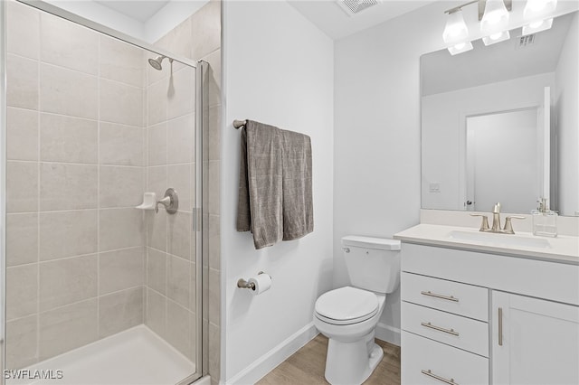 bathroom featuring walk in shower, hardwood / wood-style flooring, vanity, and toilet