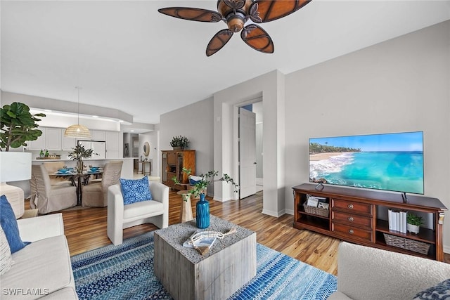 living room with ceiling fan and light hardwood / wood-style flooring