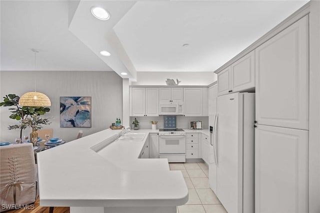 kitchen featuring hanging light fixtures, white appliances, light tile patterned floors, sink, and kitchen peninsula